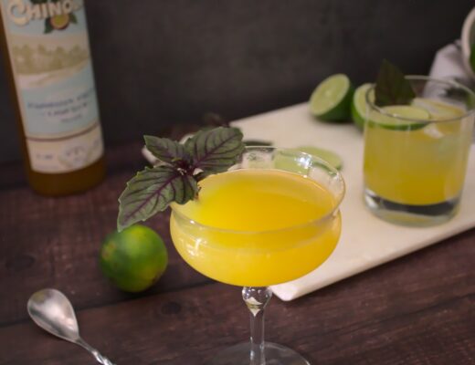 Photo of passion fruit daiquiri served in a coupe glass garnished with basil