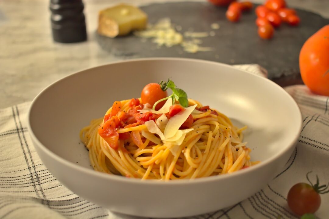 Roasted tomato and bucatini pasta plated in a bowl