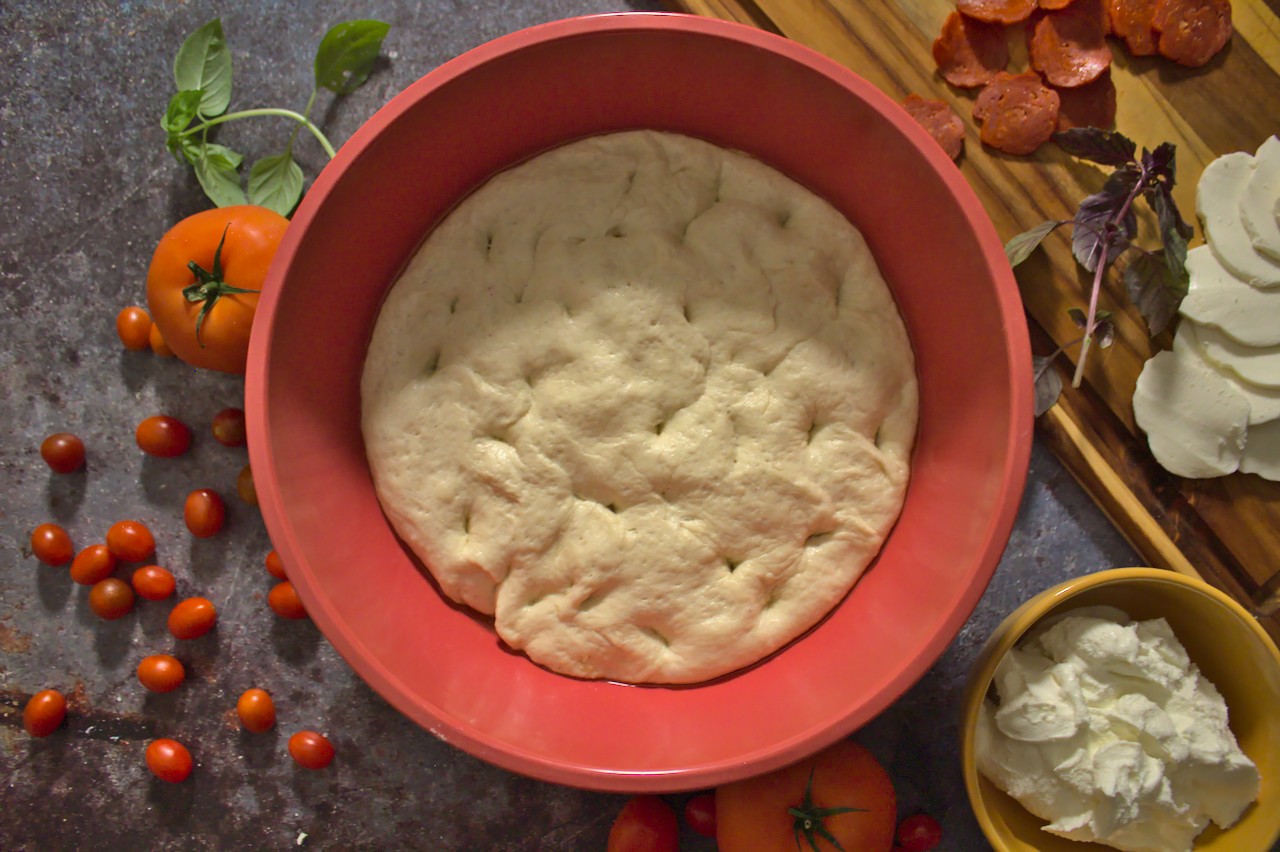 Pizza dough in a bowl after rising