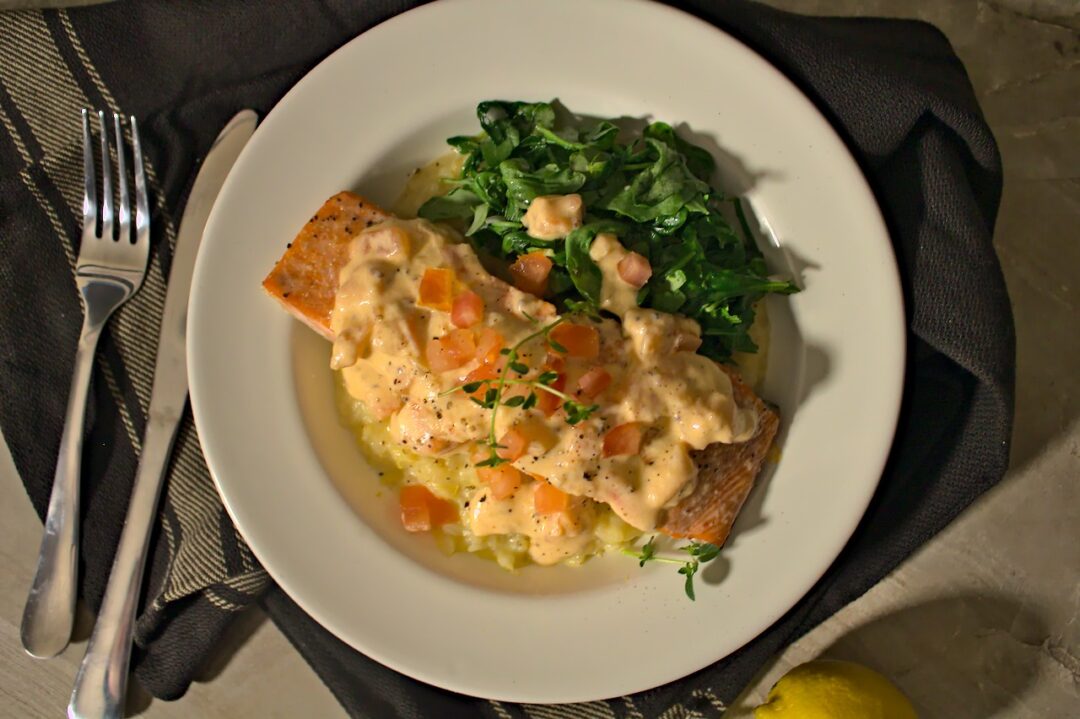 Overhead shot of roasted salmon with arugula on top of risotto