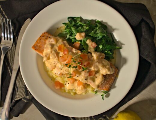 Overhead shot of roasted salmon with arugula on top of risotto