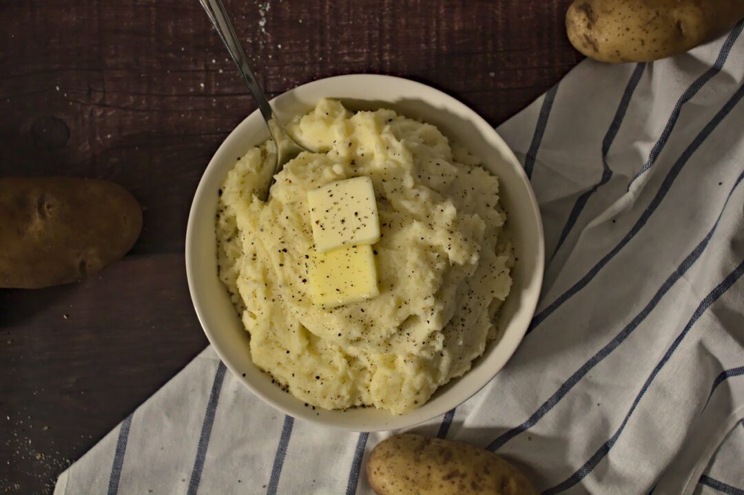 Overhead photo of mashed potatoes in a bowl with butter