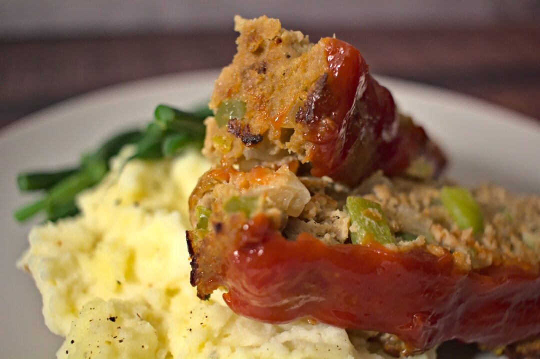 Closeup photo of meatloaf on a bed of mashed potatoes
