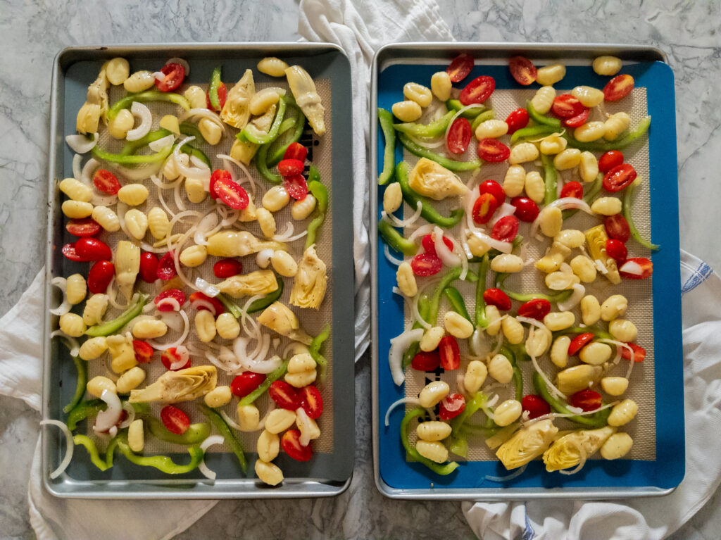 Overhead shot of gnocchi and vegetables on cooking sheets