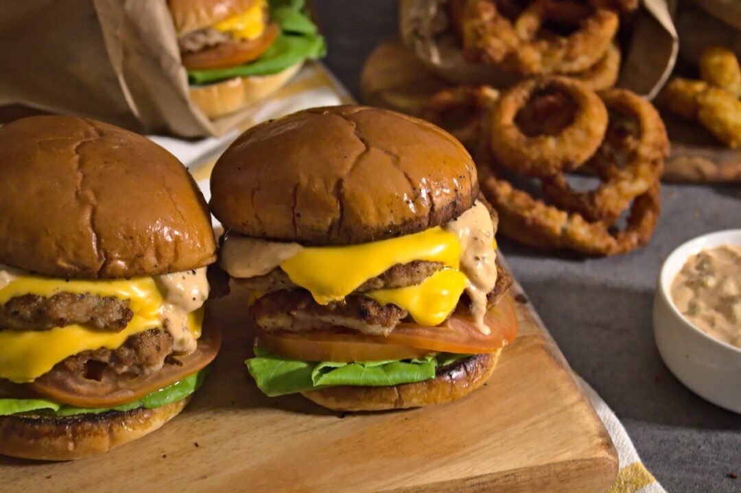 Photo of turkey burgers surrounded by onion rings and tater tots