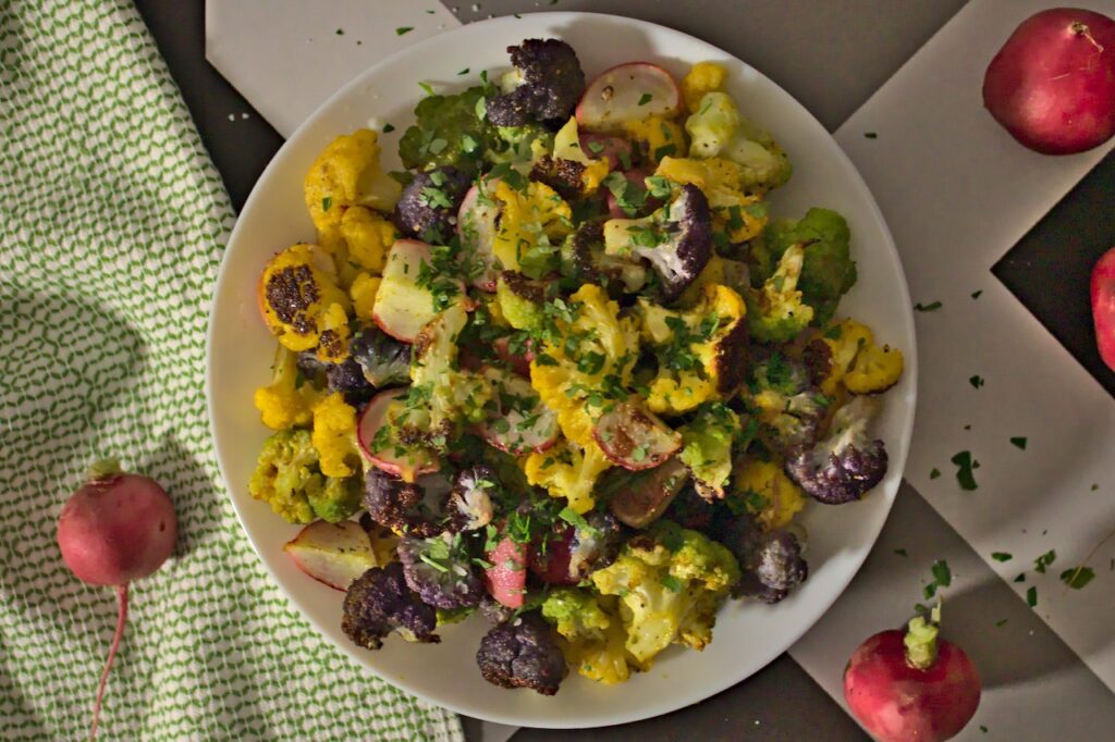 Overhead photo of roasted rainbow cauliflower and radishes