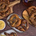 Photo of baked soft pretzels with beer cheese dip and a beer