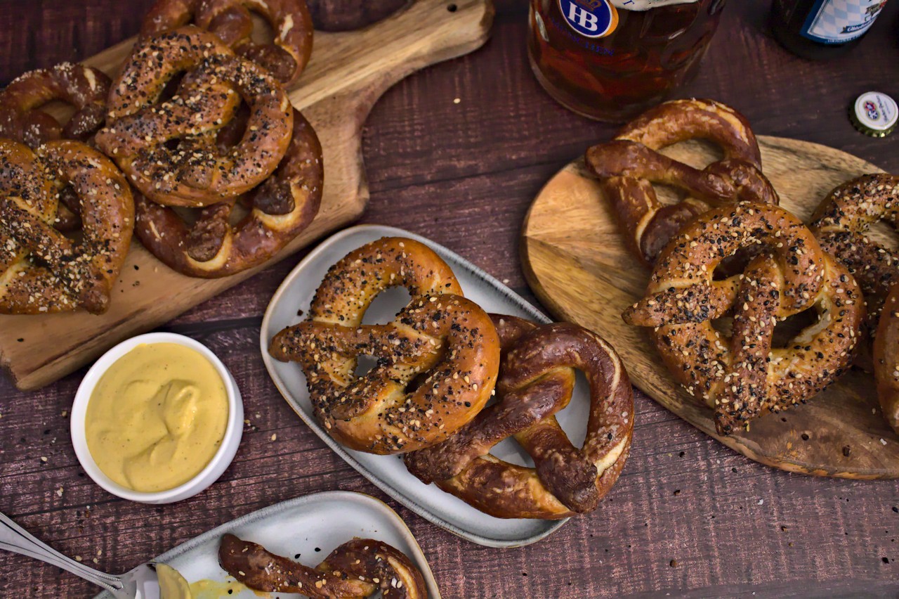 Photo of baked soft pretzels with beer cheese dip and a beer